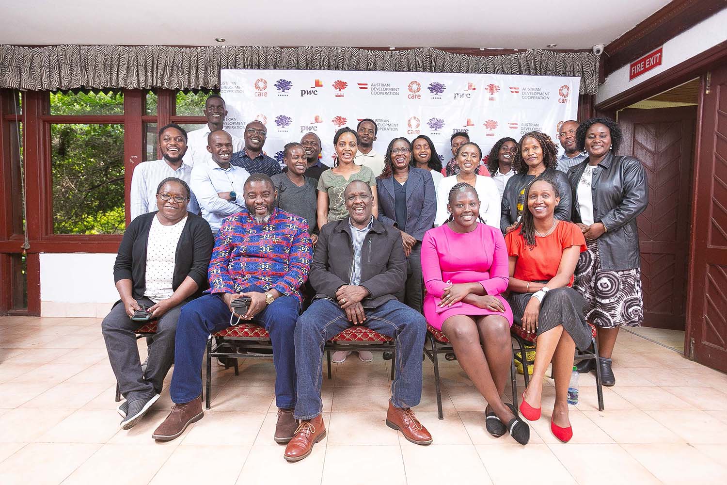 Group picture of participants and organisers of the Ashoka Visionary Program in East Africa. Sitting inside the event location, logos of the supporting organisations in the background.