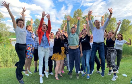 Group picture of the last module of the Ashoka Visionary Program in Central and Eastern Europe. Participants and organisers on a meadow, jumping up with stretched arms.