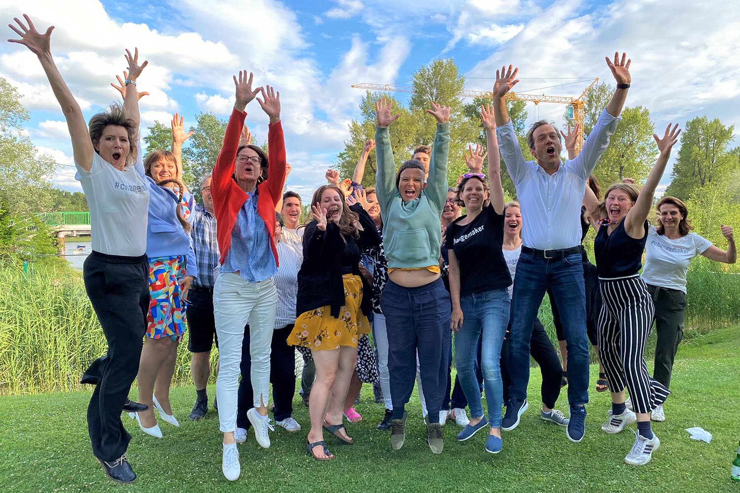 Group picture of the last module of the Ashoka Visionary Program in Central and Eastern Europe. Participants and organisers on a meadow, jumping up with stretched arms.